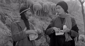 Movie still from “Two Women” (1960), directed by Vittorio De Sica – A man and a woman standing in front of a flock of sheep; Medium shot, Over the shoulder angle