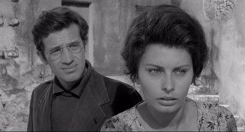 Movie still from “Two Women” (1960), directed by Vittorio De Sica – A man and a woman standing next to each other in front of a building; Close Up shot, Low angle