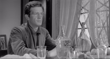 Movie still from “Two Women” (1960), directed by Vittorio De Sica – A man sitting at a dinner table with a wine decanter; Medium shot, Over the shoulder angle