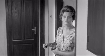 Movie still from “Two Women” (1960), directed by Vittorio De Sica – A woman holding a hair brush in front of a mirror; Medium shot, Low angle