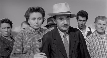 Movie still from “Two Women” (1960), directed by Vittorio De Sica – An old photo of a man and a woman standing next to each other; Medium shot, Low angle