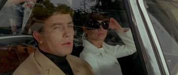 Movie still from “Two for the Road” (1967), directed by Stanley Donen – A man and a woman wearing sunglasses in a car; Close Up shot, Low angle