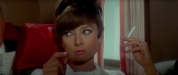 Movie still from “Two for the Road” (1967), directed by Stanley Donen – A person wearing a white shirt and sunglasses; Close Up shot, Over the shoulder angle