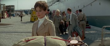 Movie still from “Two for the Road” (1967), directed by Stanley Donen – A group of people walking down a street; Medium shot, Over the shoulder angle