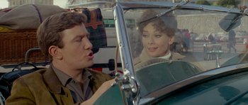 Movie still from “Two for the Road” (1967), directed by Stanley Donen – A man sitting next to a woman in the back of a car; Close Up shot, Over the shoulder angle