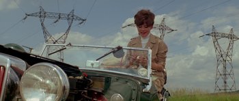 Movie still from “Two for the Road” (1967), directed by Stanley Donen – A woman sitting in the back of an antique car; Medium shot, Low angle