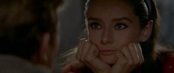 Movie still from “Two for the Road” (1967), directed by Stanley Donen – A person with her hands under her chin; Close Up shot, Over the shoulder angle
