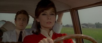 Movie still from “Two for the Road” (1967), directed by Stanley Donen – A woman driving a car in a field; Close Up shot, Over the shoulder angle