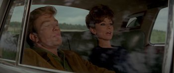 Movie still from “Two for the Road” (1967), directed by Stanley Donen – A man and a woman sitting in the back of a car; Medium shot, High angle