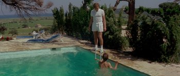 Movie still from “Two for the Road” (1967), directed by Stanley Donen – A man standing on a diving board next to a boy in a swimming pool; Wide shot, High angle