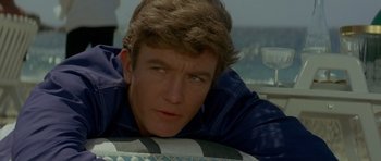 Movie still from “Two for the Road” (1967), directed by Stanley Donen – A young man is looking at the camera while lying on a pillow; Close Up shot, High angle