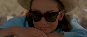 Movie still from “Two for the Road” (1967), directed by Stanley Donen – A person wearing a hat and sunglasses; Close Up shot, High angle