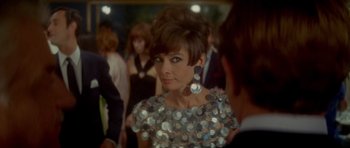 Movie still from “Two for the Road” (1967), directed by Stanley Donen – A woman in a silver sequined dress looking into a mirror; Close Up shot, Over the shoulder angle