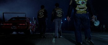 Movie still from “Two-Lane Blacktop” (1971), directed by Monte Hellman – A group of men walking down a street at night; Wide shot, Low angle
