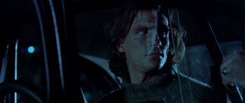 Movie still from “Two-Lane Blacktop” (1971), directed by Monte Hellman – A man with long hair sitting in the back of a car; Close Up shot, Low angle