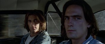 Movie still from “Two-Lane Blacktop” (1971), directed by Monte Hellman – Two young men sitting in the back seat of a car; Close Up shot, Low angle