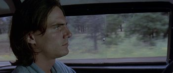Movie still from “Two-Lane Blacktop” (1971), directed by Monte Hellman – A man sitting in a car looking out the window; Close Up shot, Over the shoulder angle