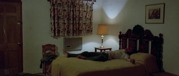 Movie still from “Two-Lane Blacktop” (1971), directed by Monte Hellman – A person laying on a bed in a room; Wide shot, High angle