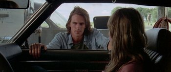 Movie still from “Two-Lane Blacktop” (1971), directed by Monte Hellman – A man sitting in the back of a car looking at a woman; Close Up shot, Over the shoulder angle
