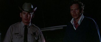 Movie still from “Two-Lane Blacktop” (1971), directed by Monte Hellman – Two men standing next to each other in the dark; Close Up shot, Low angle