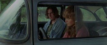 Movie still from “Two-Lane Blacktop” (1971), directed by Monte Hellman – A man and a woman sitting in a car looking out the window; Medium shot, Over the shoulder angle