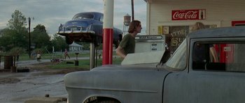Movie still from “Two-Lane Blacktop” (1971), directed by Monte Hellman – A man standing next to an old gas pump; Wide shot, Low angle