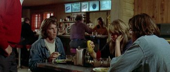 Movie still from “Two-Lane Blacktop” (1971), directed by Monte Hellman – A group of people sitting at a table in a restaurant; Medium shot, Over the shoulder angle