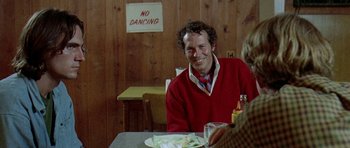 Movie still from “Two-Lane Blacktop” (1971), directed by Monte Hellman – A man sitting at a table with a plate in front of him; Medium shot, Over the shoulder angle