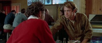 Movie still from “Two-Lane Blacktop” (1971), directed by Monte Hellman – A man sitting at a table in front of a woman; Close Up shot, Over the shoulder angle