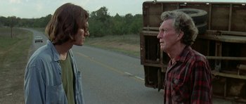 Movie still from “Two-Lane Blacktop” (1971), directed by Monte Hellman – A man and a woman standing on the side of a road; Medium shot, Over the shoulder angle