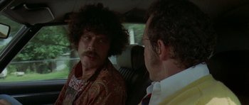 Movie still from “Two-Lane Blacktop” (1971), directed by Monte Hellman – A man in a car looking into a mirror; Close Up shot, Over the shoulder angle