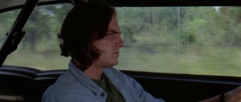 Movie still from “Two-Lane Blacktop” (1971), directed by Monte Hellman – A man sitting in a car looking out the window; Close Up shot, Low angle