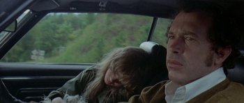 Movie still from “Two-Lane Blacktop” (1971), directed by Monte Hellman – A woman sleeping in the back of a car next to a man; Close Up shot, High angle