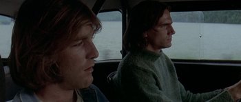 Movie still from “Two-Lane Blacktop” (1971), directed by Monte Hellman – Two men sitting in the back seat of a car looking out at the water; Close Up shot, Low angle