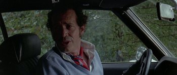 Movie still from “Two-Lane Blacktop” (1971), directed by Monte Hellman – A man sitting in the driver's seat of a car; Close Up shot, Over the shoulder angle