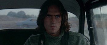 Movie still from “Two-Lane Blacktop” (1971), directed by Monte Hellman – A person with long hair in a car; Close Up shot, Low angle