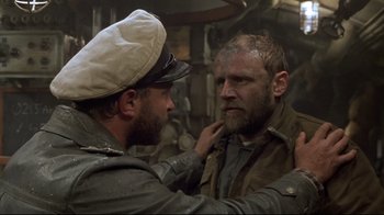 Movie still from “U-571” (2000), directed by Jonathan Mostow – Two men in military uniforms one of whom is putting on the other's hat; Medium shot, Over the shoulder angle