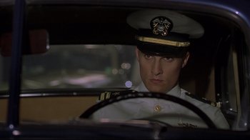 Movie still from “U-571” (2000), directed by Jonathan Mostow – A man in a uniform sitting in the driver's seat of a car; Close Up shot, Low angle