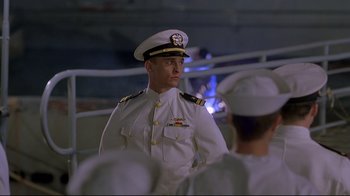 Movie still from “U-571” (2000), directed by Jonathan Mostow – A man in a white military uniform standing in front of a group of people; Medium shot, Low angle