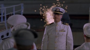 Movie still from “U-571” (2000), directed by Jonathan Mostow – A man in a uniform standing in front of fireworks; Medium shot, Low angle