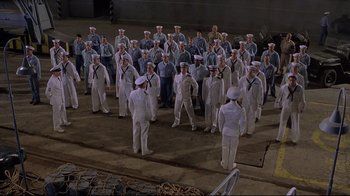 Movie still from “U-571” (2000), directed by Jonathan Mostow – A group of sailors standing in formation on a dock; Extreme Wide shot, High angle
