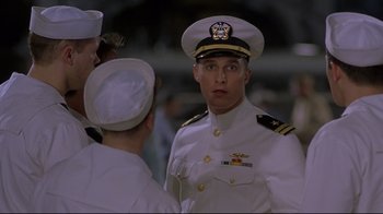 Movie still from “U-571” (2000), directed by Jonathan Mostow – A man in a white uniform is talking to two other men; Medium shot, Low angle