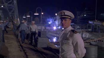 Movie still from “U-571” (2000), directed by Jonathan Mostow – A man in a uniform standing in front of a train track; Medium shot, Low angle