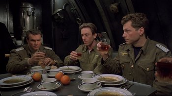 Movie still from “U-571” (2000), directed by Jonathan Mostow – A group of men sitting at a table with plates of food; Medium shot, High angle