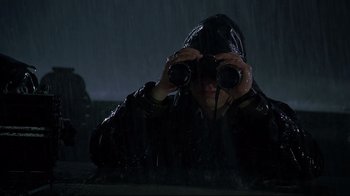 Movie still from “U-571” (2000), directed by Jonathan Mostow – A person looking through binoculars while standing in the rain; Medium shot, High angle