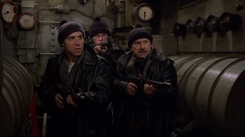 Movie still from “U-571” (2000), directed by Jonathan Mostow – A group of three men holding guns in a room; Medium shot, High angle