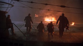 Movie still from “U-571” (2000), directed by Jonathan Mostow – A group of people standing on a dock near a fire; Wide shot, Low angle