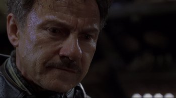 Movie still from “U-571” (2000), directed by Jonathan Mostow – An old man with a mustache and a beard looking at the camera; Close Up shot, Low angle