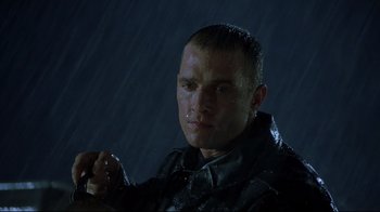 Movie still from “U-571” (2000), directed by Jonathan Mostow – A man in a leather jacket is in the pouring rain; Close Up shot, Low angle
