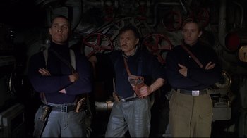 Movie still from “U-571” (2000), directed by Jonathan Mostow – A group of men standing next to each other in a room; Medium shot, Low angle